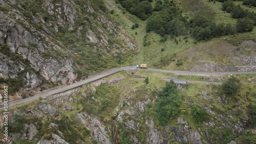 Lateral Aerial Truck on a Dangerous High Mountain Road between Rocks and Trees. Going Down. Asturias, Spain.