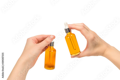 Bottle with oil in woman hand isolated on white.