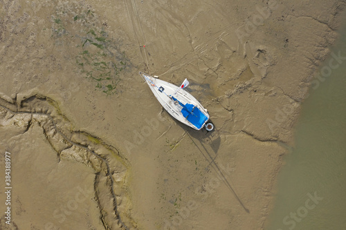 Aerial view of yacht aground on a muddy shore in Southampton in the United Kingdom. Image with space for text.