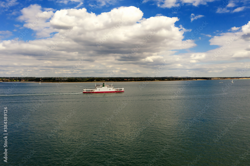Car ferry in Southampton Water on a beautiful sunny day with clouds in the blue sky. With space for text.