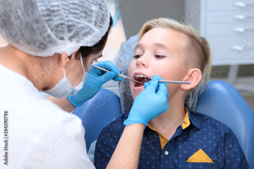 A little boy is being examined in a dental office. A dentist examines the child's oral cavity. Open mouth. Disease prevention.The concept of health.