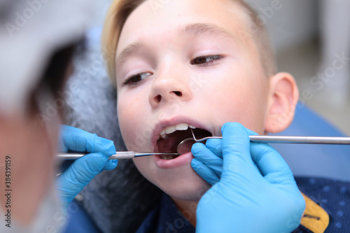 Dentist examines the teeth of a little boy. Appointment with a children's dentist. Close up. Out of focus.