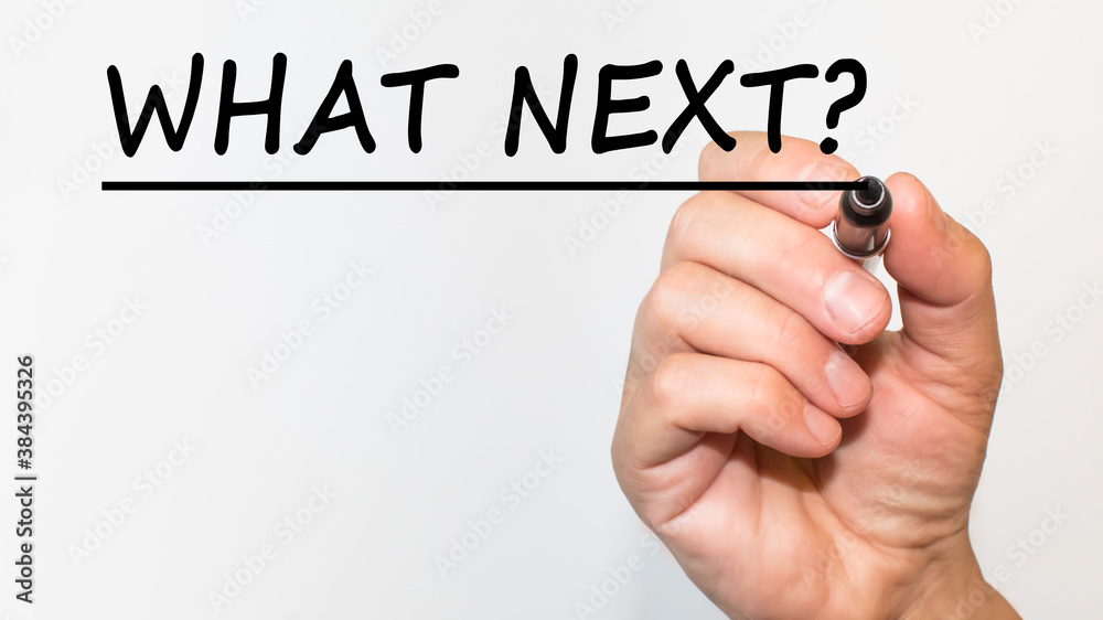 the hand writes the Word WHAT NEXT with a marker on a white background. business concept the hand writes the Word WHAT NEXT with a marker on a white background. business concept