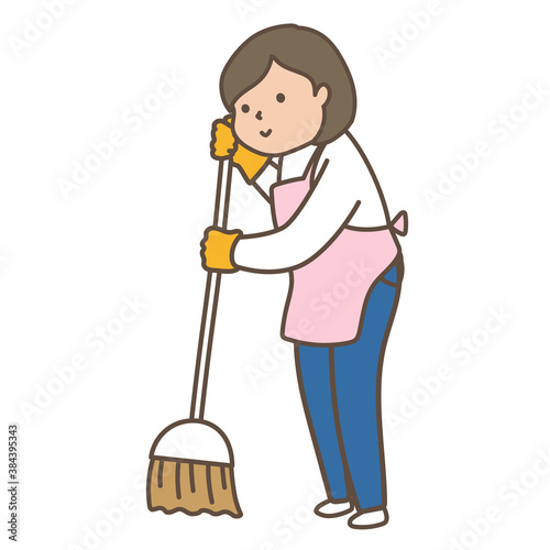 箒で掃き掃除をするエプロンを着た女性