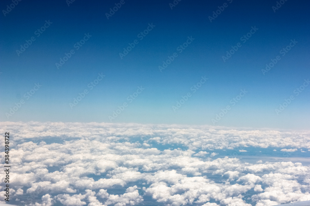 View from the plane window to cumulus clouds and blue sky. View from the plane window to cumulus clouds and blue sky.