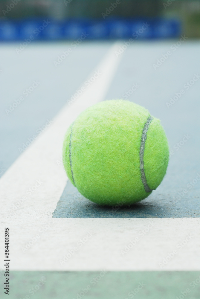 Tennis ball on concrete blue field with white line