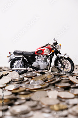 Modern classic motorcycle model on many of coins background, Finance concept. photo