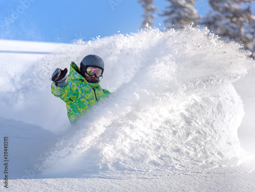 Freerider snowboarder moving down in snow powder. snowboard snow explosion. for a poster and advertising of a ski resort. winter extreme sports