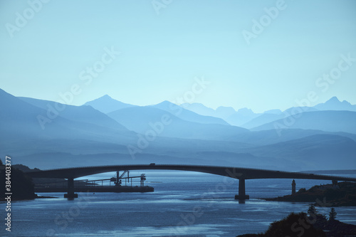 Silhouette of the arch bridge over the lake against the backdrop of beautiful mountains. Skye Bridge. Scotland, United Kingdom photo