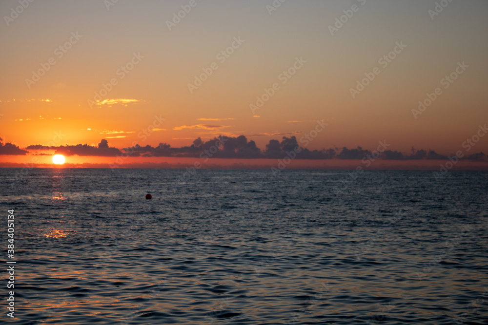 Wonderful panoramic view of the sunset over the Sochi sea with dark red clouds.