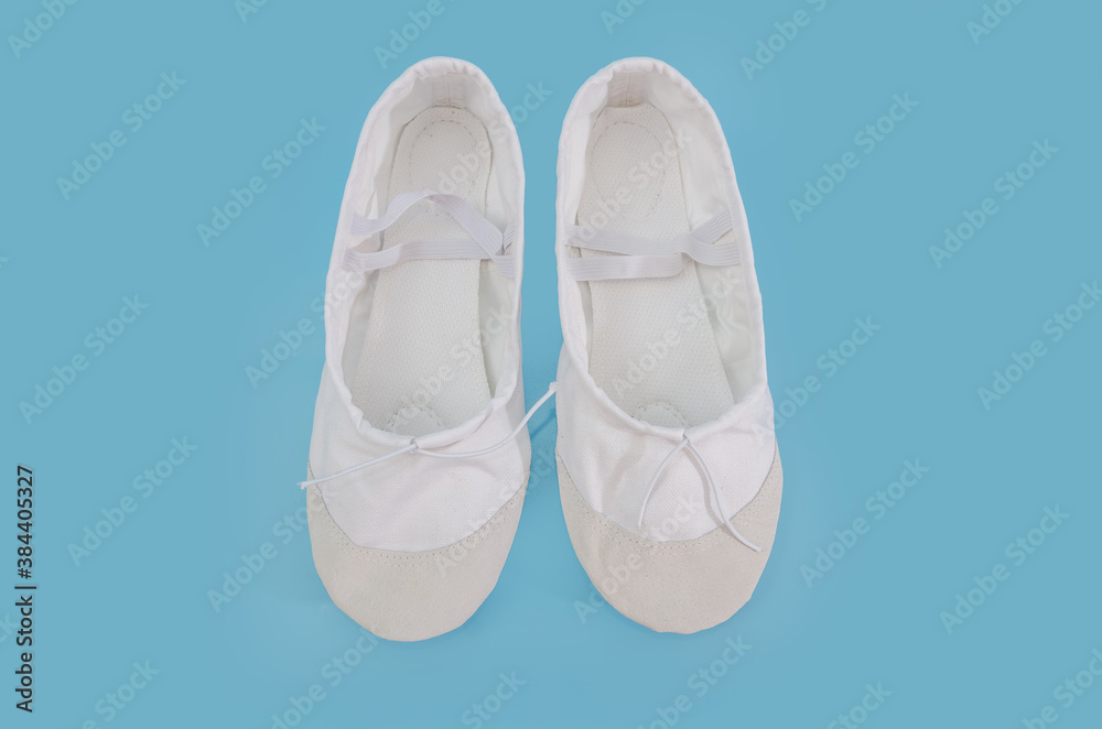 White ballet flats for dancing isolated on blue background. Shoes for trainers in the fitness room.
