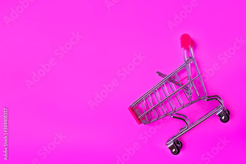Empty shopping cart trolley with some copy space can put letters on pink background.