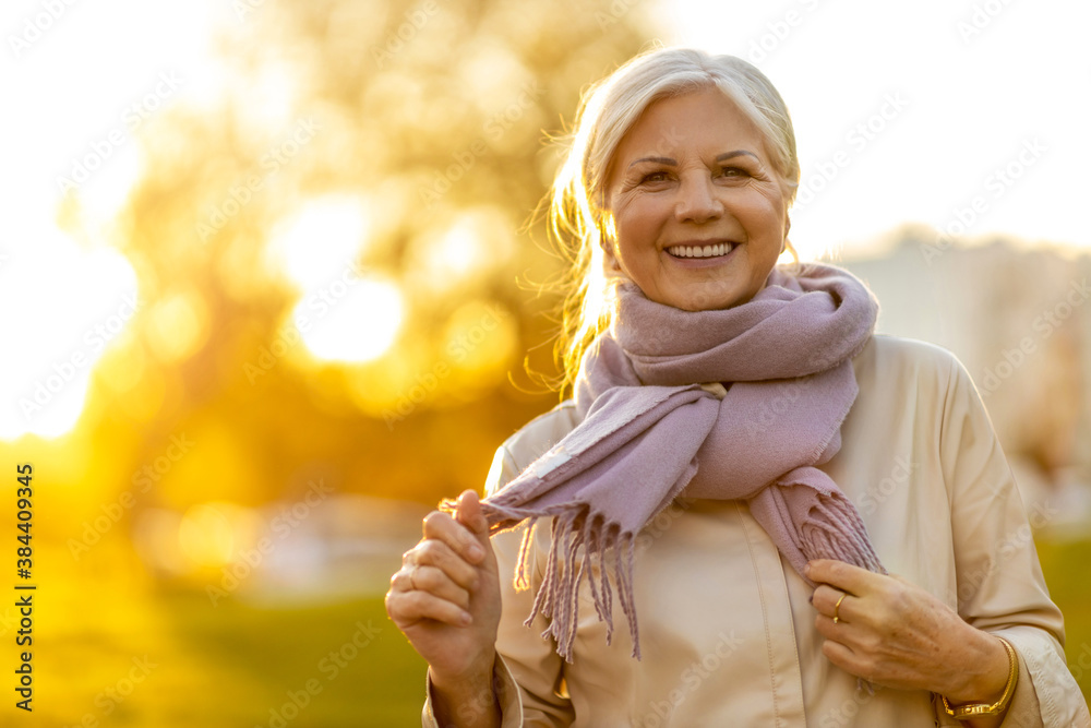 Senior woman enjoying autumn colors at sunset
 - obrazy, fototapety, plakaty 