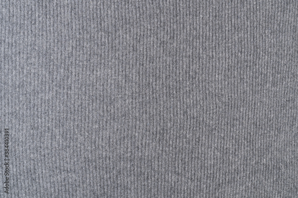 Background texture of grey knitted fabric made of wool with vertical stripes. Background texture of grey knitted fabric made of wool with vertical stripes.
