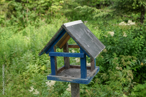 blue birdhouse on a background of green grass