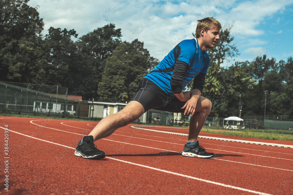 Fototapeta premium Young Caucasian man doing strength exercises, side step lunges