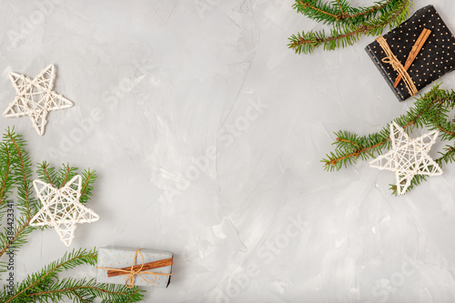 Light Christmas composition with place for text. Fir branches, holiday stars, homemade gifts on a white background. Flat lay, top view.