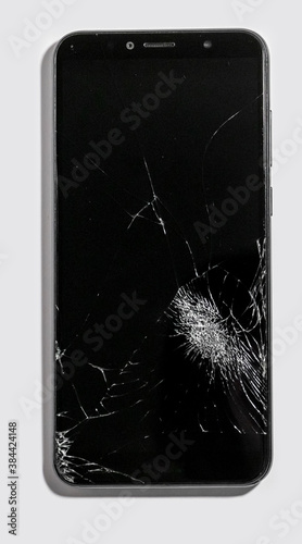 Repair of mobile devices. Broken touchscreen display of black smartphone. Close-up damage.