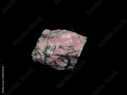 Sample of the mineral pink rhodonite on a black background. Manganese compound.
