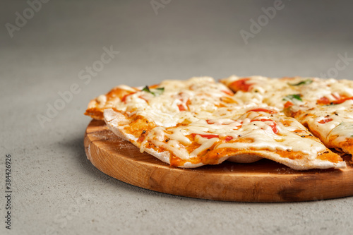 Vegetarian pizza on a wooden Board on a concrete background