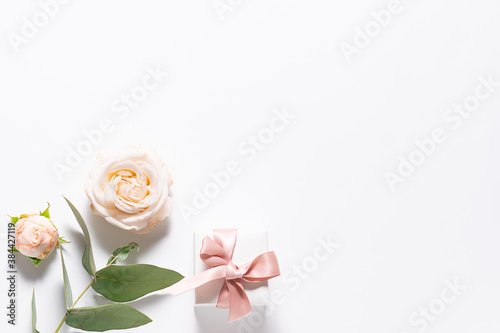 Minimalism style festive composition with gift box for jewelry rose flowers and eucalyptus twig. Greeting or invitation card mock up.
