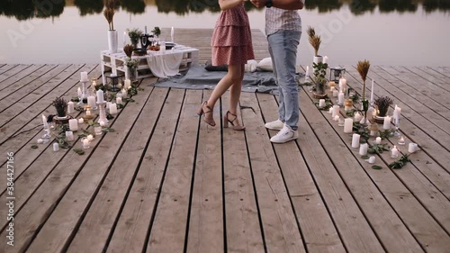 Detail with the feet of a couple in love, while rotating on a deck. Bridge arranged with decoration for marriage requests. Marriage proposal concept. Romantic couple. Slow video.