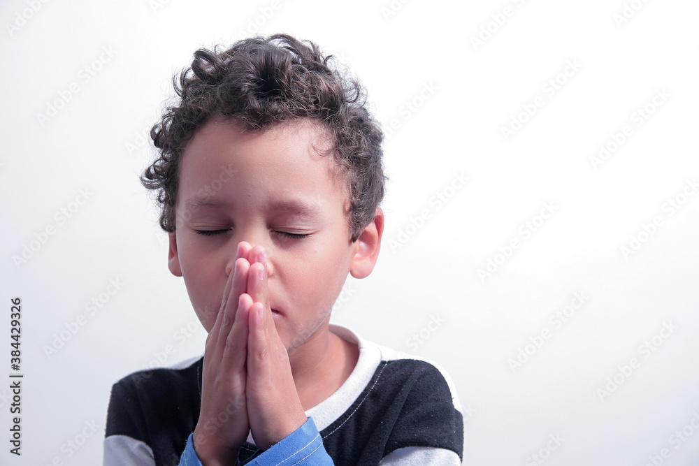 boy praying to God with hands held together with closed eyes on white background stock photo boy praying to God with hands held together with closed eyes on white background stock photo