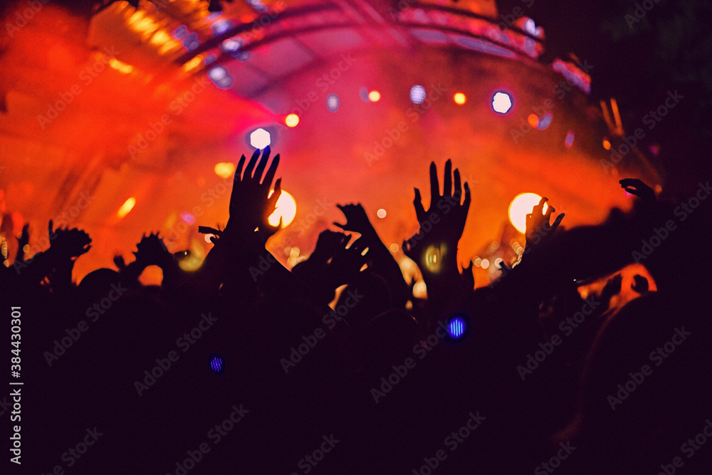 Abstract blur atmosphere: happy people enjoying outdoor music festival concert, raised up hands and clapping of pleasure, active night life concept, play of light and shadow on the stage Abstract blur atmosphere: happy people enjoying outdoor music festival concert, raised up hands and clapping of pleasure, active night life concept, play of light and shadow on the stage