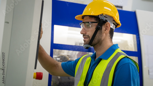 Engineer inspecting and checking operating process on machine monitor.