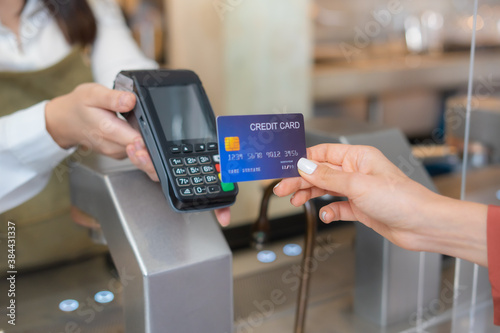 Customer use wireless credit card with EDC at cashier in restaurant.