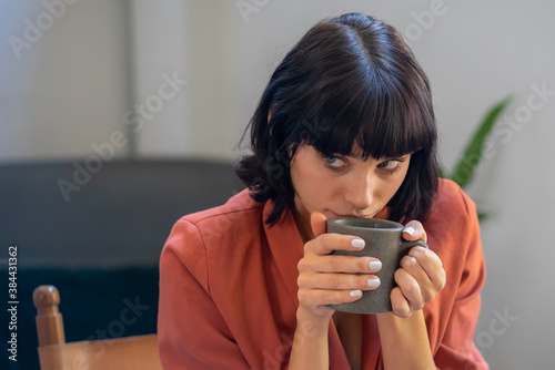 Close up portrait shot of relax beautiful caucasian lady holding cup.