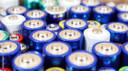 Background view of AAA AA batteries and rechargeable batteries. Choice of batteries. Energy supply and recycling concept. Textures of electrical elements packed close to each other.