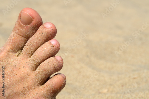 Foot and sand on the beach, selective focus © Anton_Lutsenko