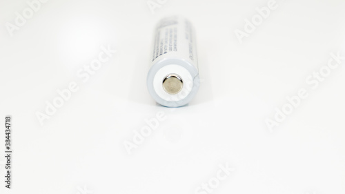 One alkaline battery on a white background with reflection. Energy supply and recycling concept. Copy space. Minimalism. Eliment AA is the most common type of galvanic batteries and accumulators.