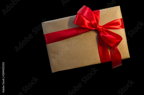 Gift box with red ribbon, copy space isolated on black background. Sales concepts, discount price, black friday, christmas gifts and shopping, greeting card for christmas, valentine's day or new year 