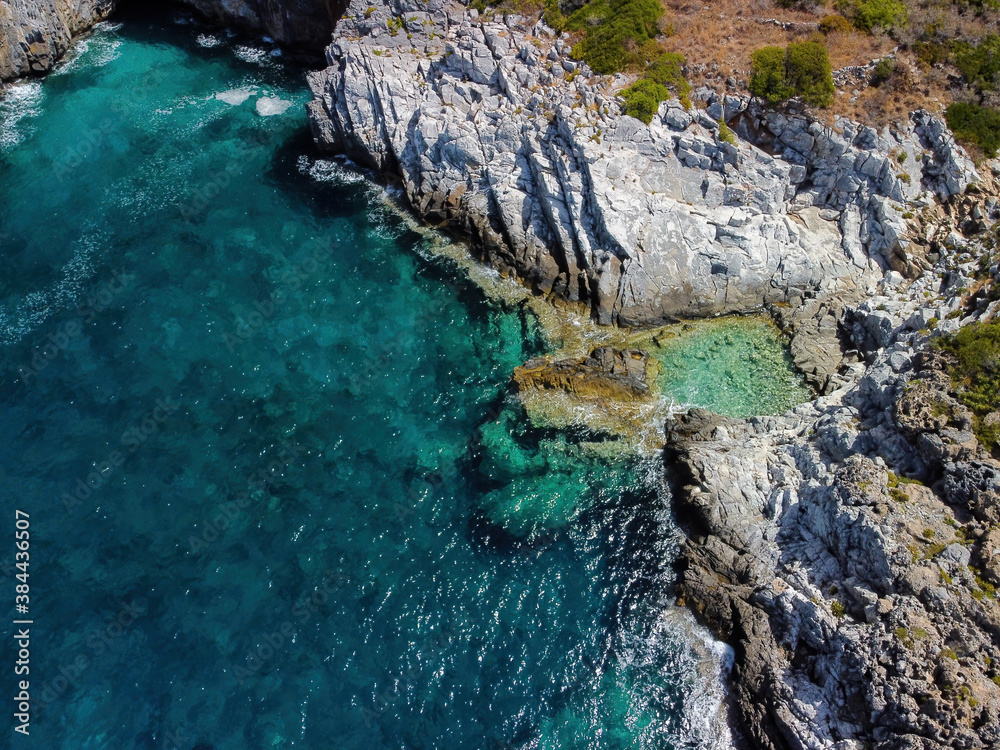 Aerial panoramic view of rocky beach and small pond near Trachila, Messinia, Greece
