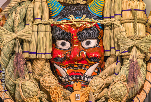 asakusa, japan - november 08 2019: Giant auspicious rake made of straw and papier-mâché decorated with a scary demon face of the Japanese folklore Namahage, turtles and a rooster at Tori-no-Ichi Fair. photo