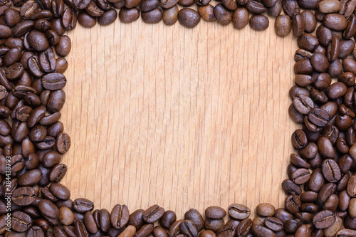 A rectangular void is laid out on a wooden surface made of coffee beans. There's room in the void for an inscription.