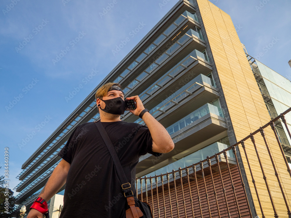 Hombre joven de negocios con el teléfono móvil y mascarilla Hombre joven de negocios con el teléfono móvil y mascarilla