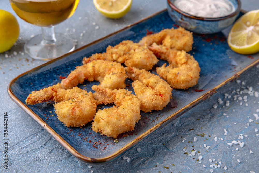 Deep-fried shrimp in batter. Natural delicious food. Greek cuisine menu. Still life in a marine style on a blue background. Deep-fried shrimp in batter. Natural delicious food. Greek cuisine menu. Still life in a marine style on a blue background.