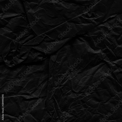 Black vintage and old looking crumpled paper background. Retro cardboard texture. Grunge paper for drawing. Ancient book page. Present wrapping.