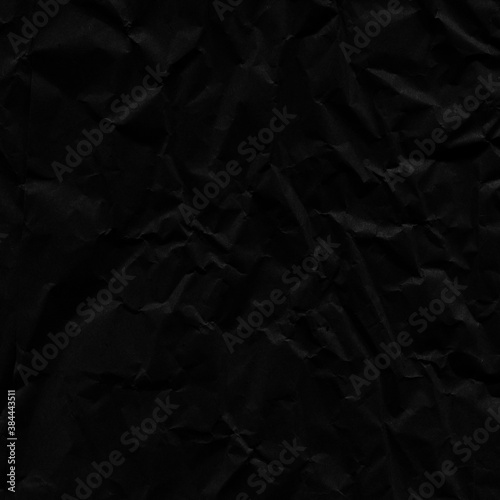 Black vintage and old looking crumpled paper background. Retro cardboard texture. Grunge paper for drawing. Ancient book page. Present wrapping.