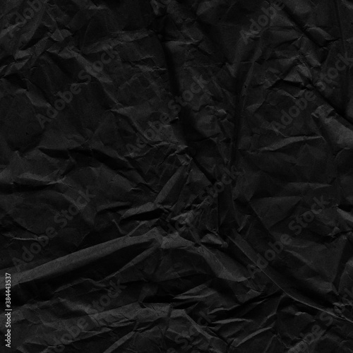 Black vintage and old looking crumpled paper background. Retro cardboard texture. Grunge paper for drawing. Ancient book page. Present wrapping.