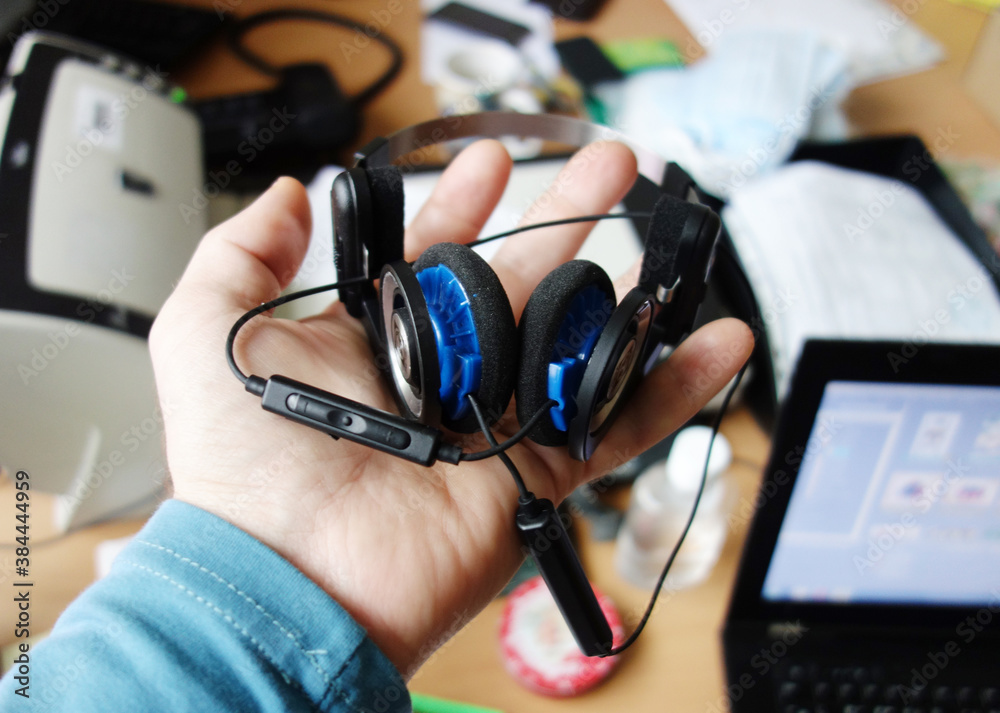 a man holding classic headphones in his hands, the concept of remote work, learning, rest. a man holding classic headphones in his hands, the concept of remote work, learning, rest.