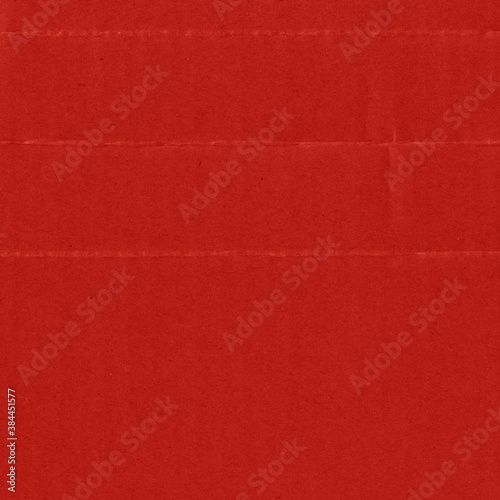 A red vintage rough sheet of carton. Recycled environmentally friendly cardboard paper texture. Simple and bright minimalist papercraft background. © artistmef