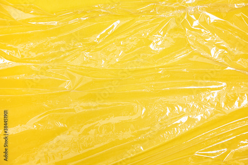Clear plastic texture with yellow color. Nylon polythene wrap. Plastic free lifestyle, ecology pollution 