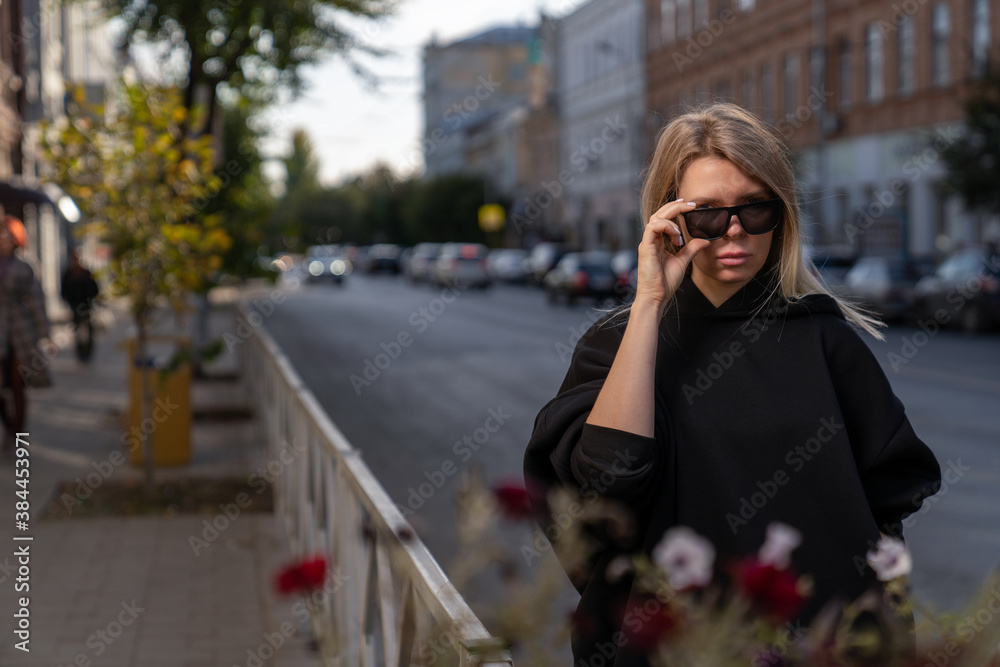 Fototapeta premium blonde girl in sunglasses on blurred background of godskoy street 