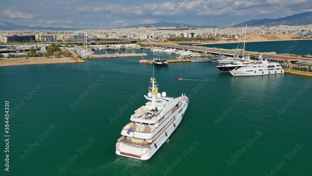 Aerial drone top down photo of luxury yacht cruising to Athens Marina and port in Piraeus, Attica, Greece