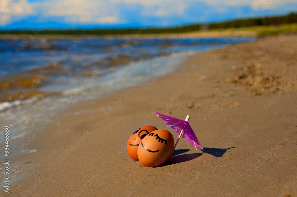 Obraz premium easter funny eggs under umbrella on a beach
