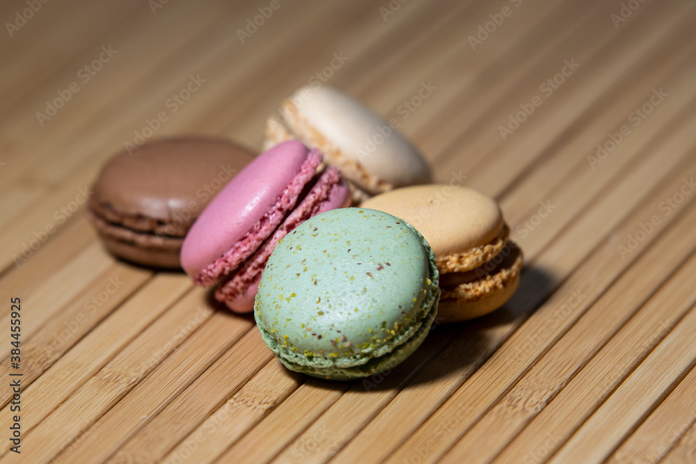 An assortment of colourful macaroons on a wooden serving board An assortment of colourful macaroons on a wooden serving board